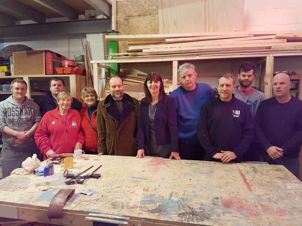 Lesley Griffiths AM with NuLife volunteers in the workshop. 